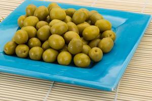 Green olives on wooden background photo