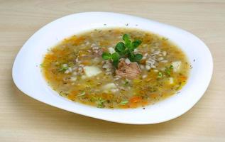 sopa de cereales en el plato y fondo de madera foto