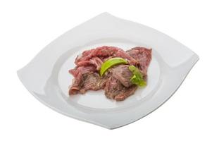 Beef carpaccio on the plate and white background photo