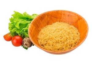 Raw pasta in a bowl on white background photo