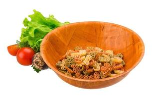 Raw pasta in a bowl on white background photo