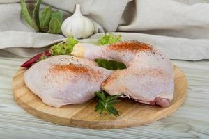 Chicken thigh on wooden background photo