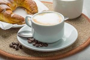 capuchino sobre tablero de madera y fondo blanco foto