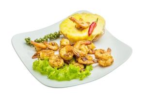 Garlic shrimps with potato on the plate and white background photo