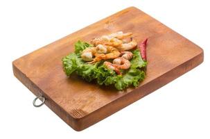 Unshelled king prawn on wooden board and white background photo