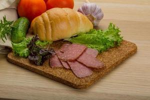 Salami sausages on wooden board and wooden background photo