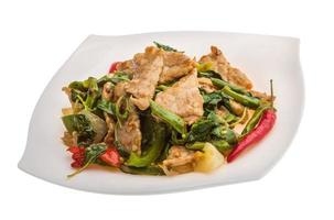 Pork with vegetables on the plate and white background photo