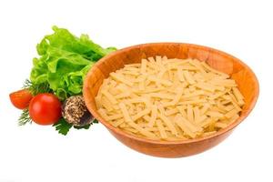 Raw pasta in a bowl on white background photo