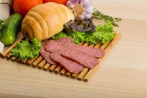 Salami on wooden board and wooden background photo