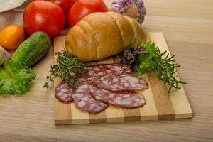 Salami on wooden board and wooden background photo