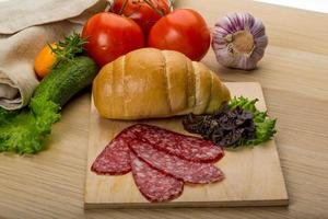 Salami on wooden board and wooden background photo