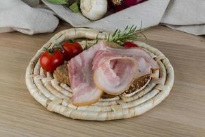 Bacon sandwich on wooden board and white background photo