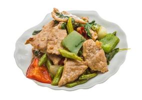 Pork with vegetables on the plate and white background photo