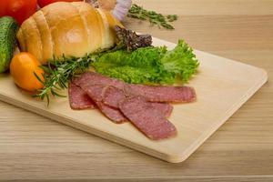 Salami on wooden board and wooden background photo