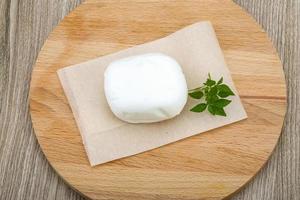 Mozzarella on wooden board and wooden background photo