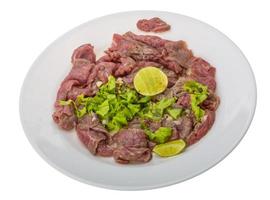 Beef carpaccio on the plate and white background photo