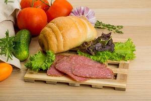 Salami on wooden board and wooden background photo