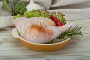 Chicken thigh on wooden background photo