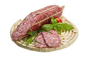 Salami on wooden board and white background photo