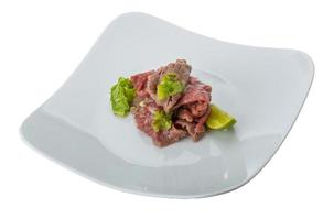 Beef carpaccio on the plate and white background photo