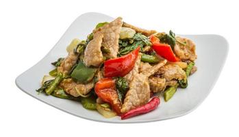 Pork with vegetables on the plate and white background photo