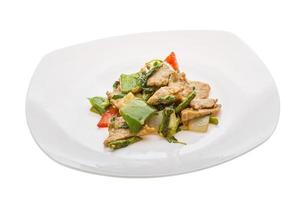 Pork with vegetables on the plate and white background photo