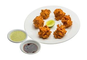 Onion bhajee on the plate and white background photo