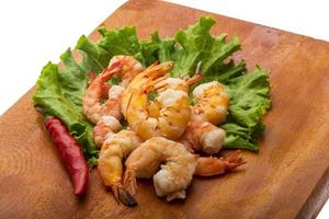 Unshelled king prawn on wooden board and white background photo