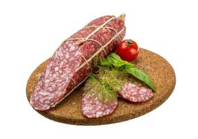 Salami on wooden board and white background photo