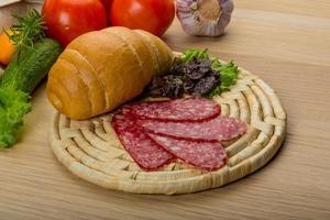 Salami on wooden board and wooden background photo