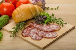 Salami on wooden board and wooden background photo