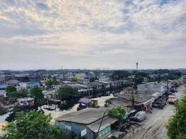 West Java, Indonesia on July 2022. Aerial view of a slum settlement on the north side of Jakarta. This settlement is located on the edge of the river. photo