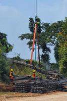 West Java, Indonesia on July 2022. Two construction workers are mobilizing pieces of structural steel. This process is carried out with the help of cranes and slings. photo