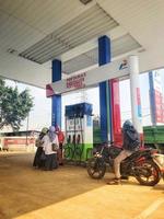 West Java, Indonesia on July 2022. Motorcyclists are queuing to refuel their motorbikes at a gas station. photo