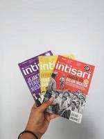 West Java, Indonesia on July 2022. A hand is holding some Intisari magazines photo