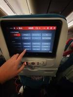 Istanbul, Turkey on July 2022. An index finger is selecting the menu to watch and listen to the Quran on the screen of a passenger on a Turkish Airlines flight. photo