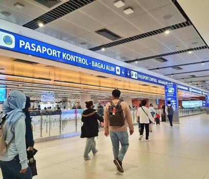 Istanbul, Turkey on July 2022. Several tourists are queuing for passport checking at the passport control counter, both local and international tourists. photo