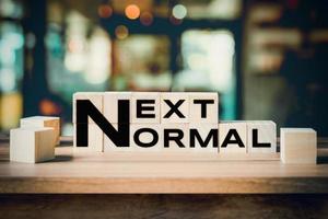 Next Normal word on wooden cube block on wood table background. photo
