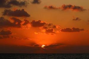 el sol se pone por debajo del horizonte en el mar mediterráneo en el norte de israel. foto