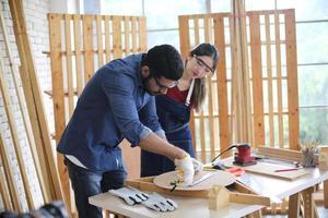 Carpenter grinding joinery product with carvings, finishing woodwork at the carpentry manufacturing photo