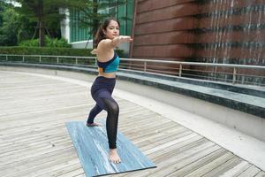 Young attractive woman doing stretching yoga exercise in the park. photo