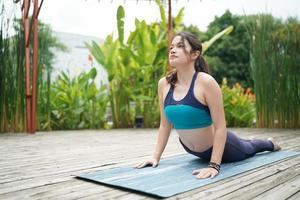 Young attractive woman doing stretching yoga exercise in the park. photo