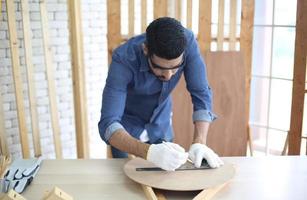 Carpenter grinding joinery product with carvings, finishing woodwork at the carpentry manufacturing photo