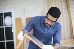 carpintero moliendo productos de carpintería con tallas, acabado de carpintería en la fabricación de carpintería foto