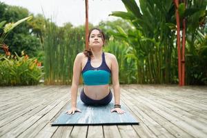 Young attractive woman doing stretching yoga exercise in the park. photo