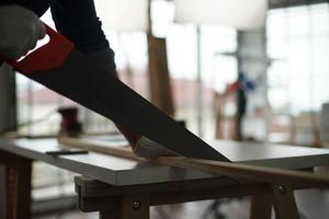 Carpenter grinding joinery product with carvings, finishing woodwork at the carpentry manufacturing photo