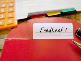 Feedback text written on paper with red envelope background. Rating review concept. Stock photo. photo