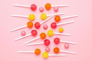 Colorful candy lollipops on pink background photo