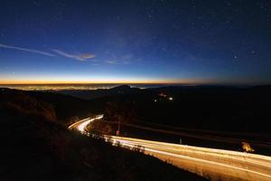 Milky way galaxy with stars and space dust in the universe and lighting on the road before morning at Doi inthanon Chiang mai, Thailand photo