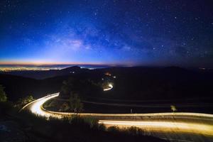 Milky way galaxy with stars and space dust in the universe and lighting on the road before morning at Doi inthanon Chiang mai, Thailand photo